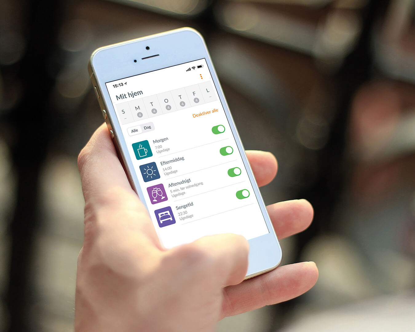 Iphone med app-funktion, der gør det muligt at styre Luxaflex plisségardiner