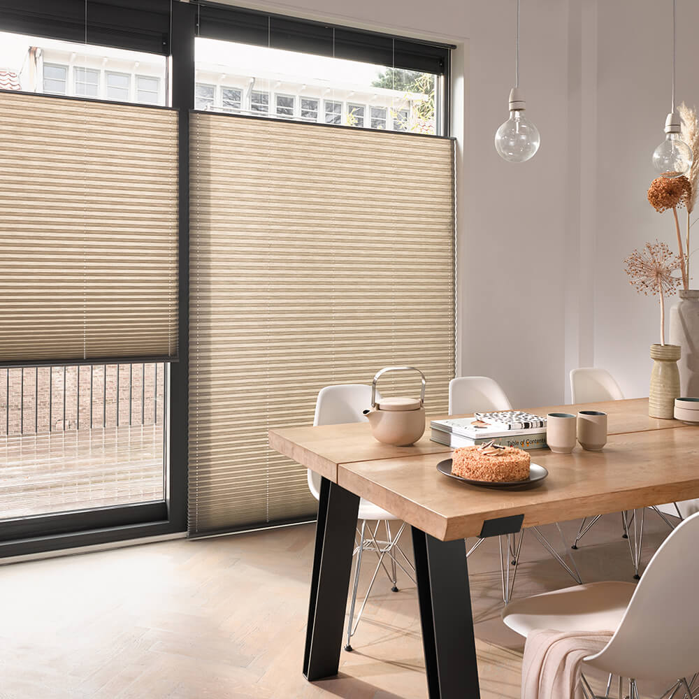 Brune Luxaflex plisségardiner i en spisestue